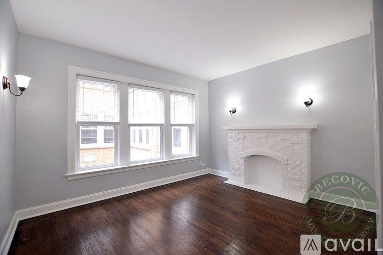 A room with a fireplace and two windows.