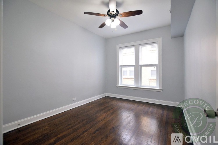 A room with a ceiling fan and a window.