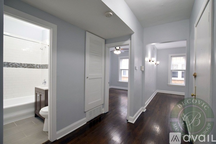 A bathroom with a toilet, sink, and a window.