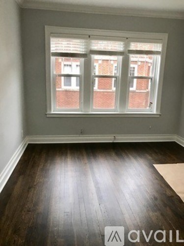 A room with a window and wooden floors.