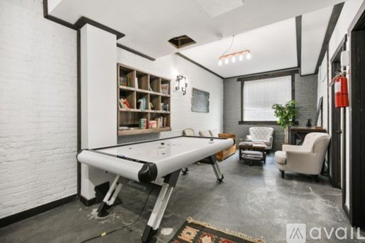 A room with a pool table and a fire extinguisher on the wall.