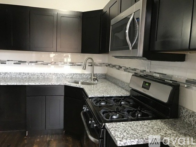 A kitchen with black cabinets and a white countertop.