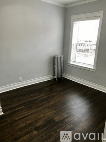A room with a window and a radiator on the wall.