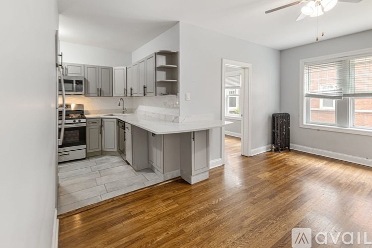 A spacious kitchen with wooden floors and a white island.