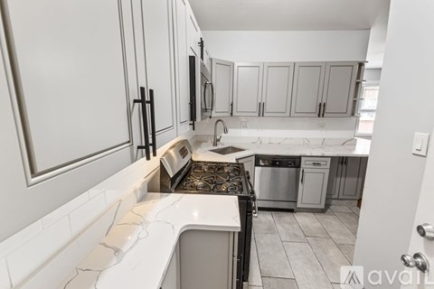 A kitchen with white cabinets and a black stove top.