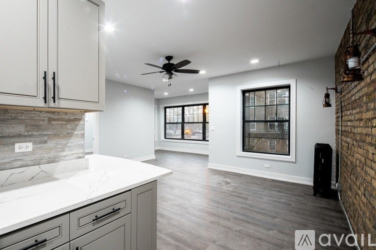 A kitchen with a white countertop and a ceiling fan.