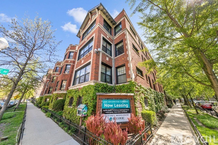 A building with a sign that says "Now Leasing" in front of it.