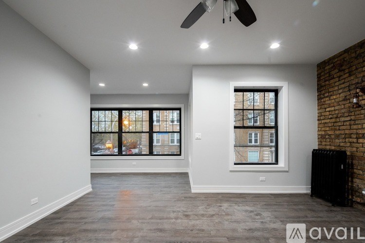 A spacious room with a ceiling fan and large windows.