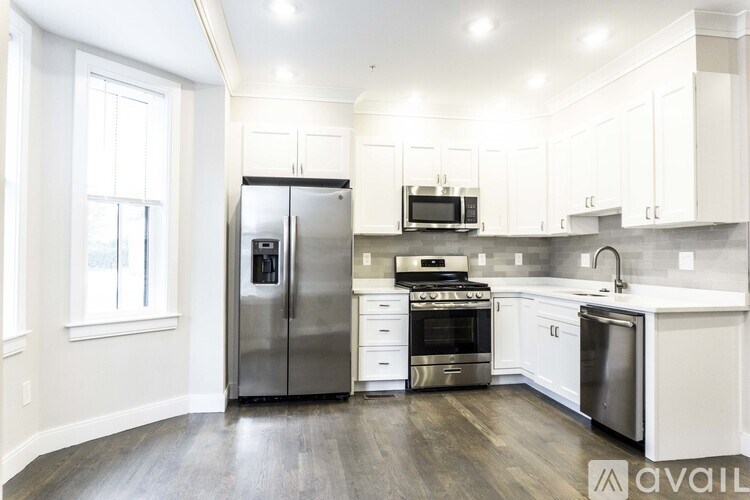 A kitchen with white cabinets and stainless steel appliances.