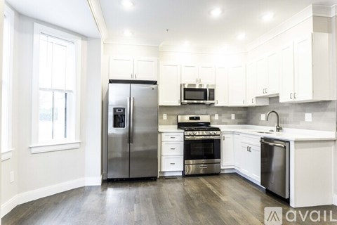 A kitchen with white cabinets and stainless steel appliances.