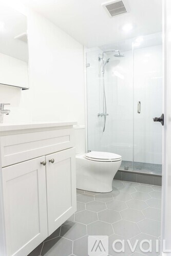 A white toilet in a bathroom with a walk-in shower.