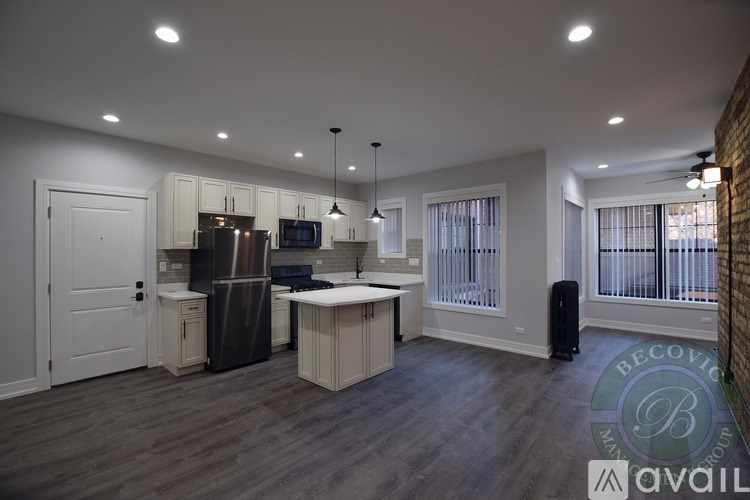A kitchen with a refrigerator, microwave, and sink.