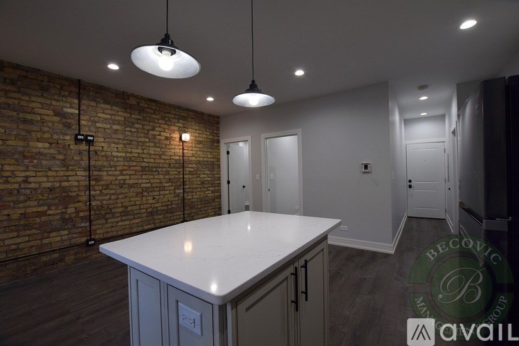 A kitchen with a white countertop and a brick wall.