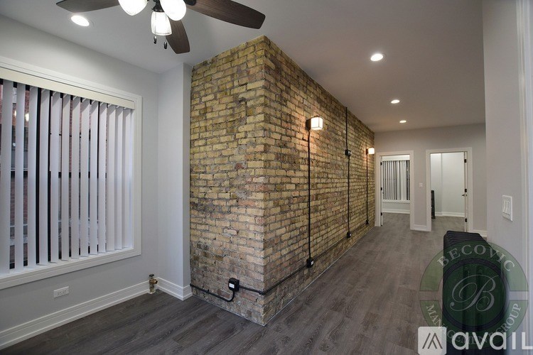 A room with a brick wall and a ceiling fan.