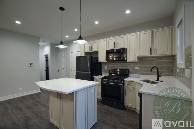 A kitchen with a white island and black appliances.