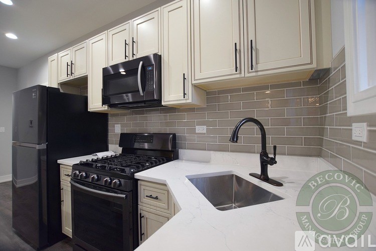 A kitchen with a black stove top oven and a black microwave above it.