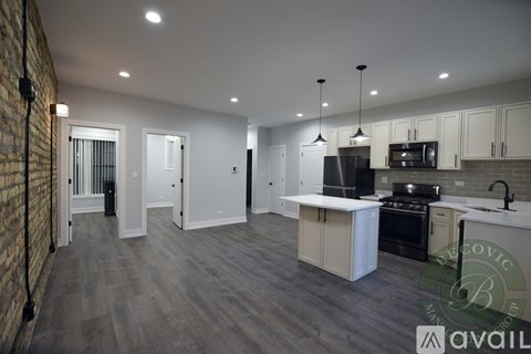 A spacious kitchen with white cabinets and a brick wall.