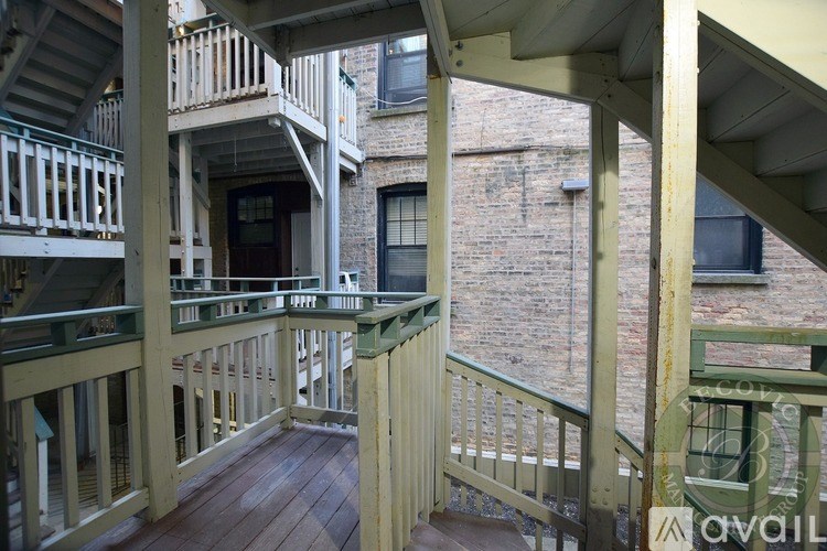 A balcony with a green railing and wooden floor.