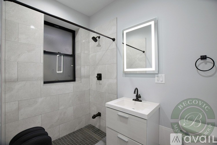 A bathroom with a white sink and a mirror above it.