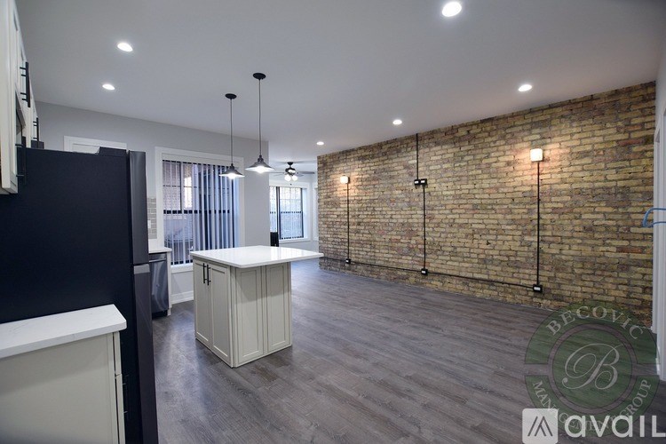 A room with a brick wall and wooden flooring.