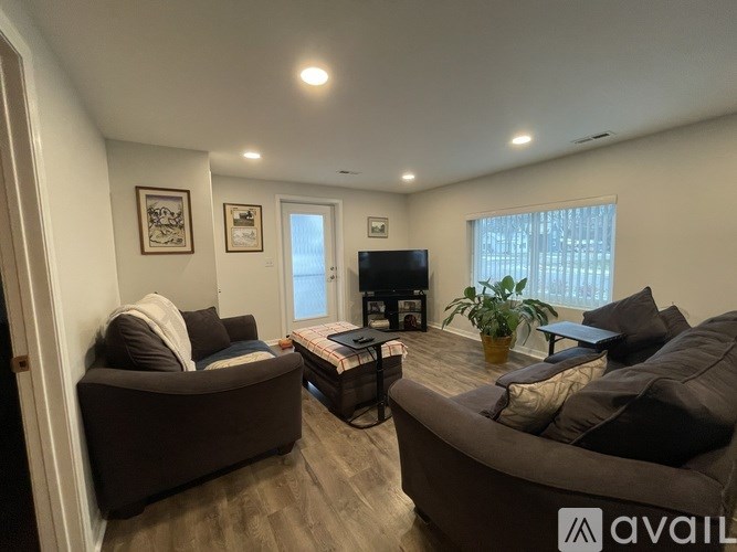 A living room with a brown couch, a coffee table, and a flat screen TV.