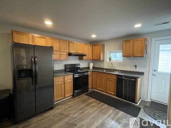A kitchen with wooden cabinets and black appliances.