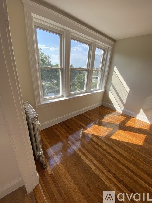 A room with a window and wooden flooring.