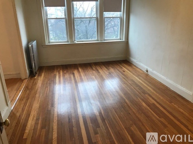 A room with wooden flooring and a window.