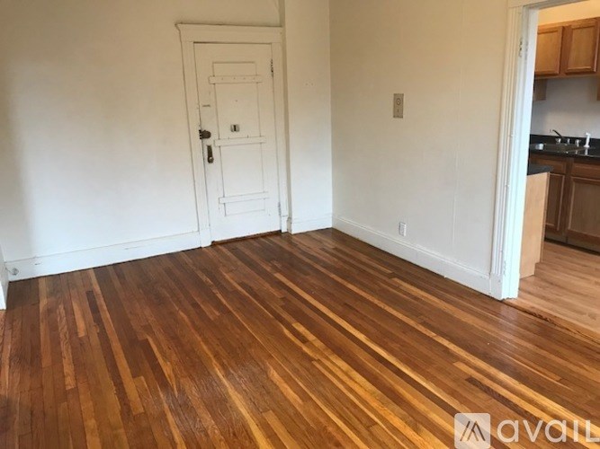 A room with wooden flooring and a white door.