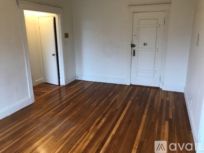 A room with wooden flooring and two doors.
