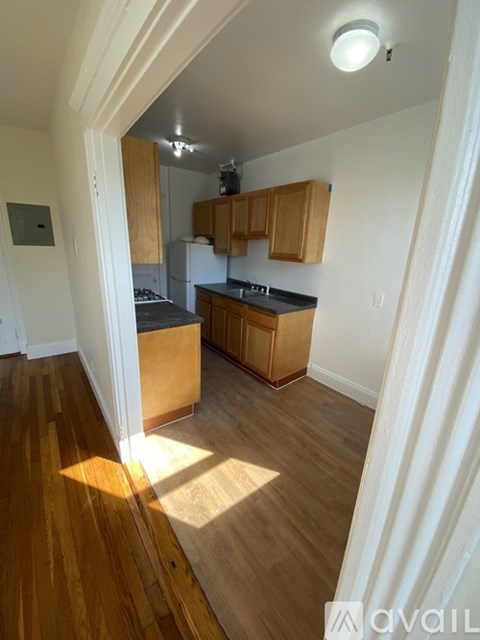 A kitchen with wooden cabinets and a black countertop.