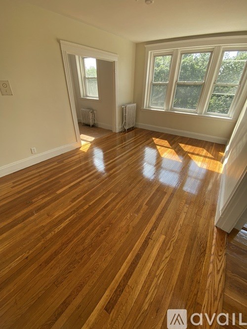 A room with wooden flooring and a window.