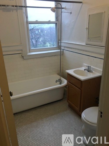 A bathroom with a tub, toilet, and sink.