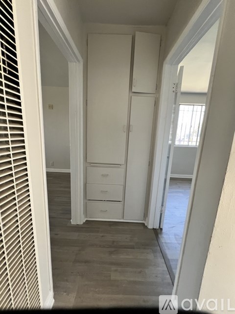A hallway with a white door and drawers.