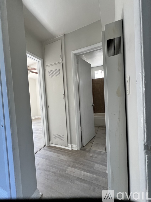 A room with a white door and a grey floor.