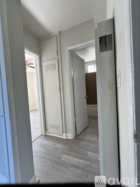 A room with a white door and a grey floor.