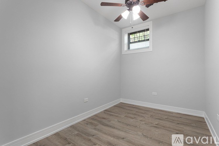 A room with a ceiling fan and a window with blinds.