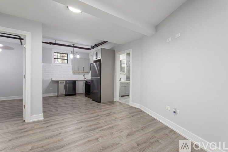 A kitchen area with a refrigerator, sink, and cabinets.