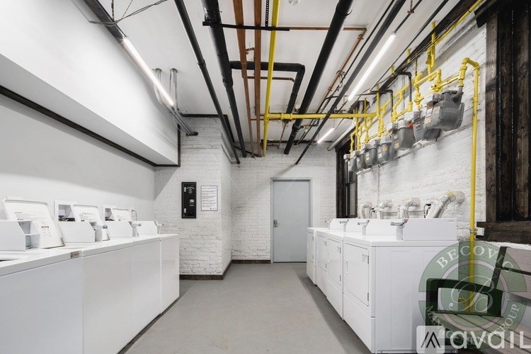 A row of washing machines are lined up in a laundromat.