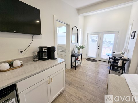 A kitchen with a black screen tv mounted on the wall.