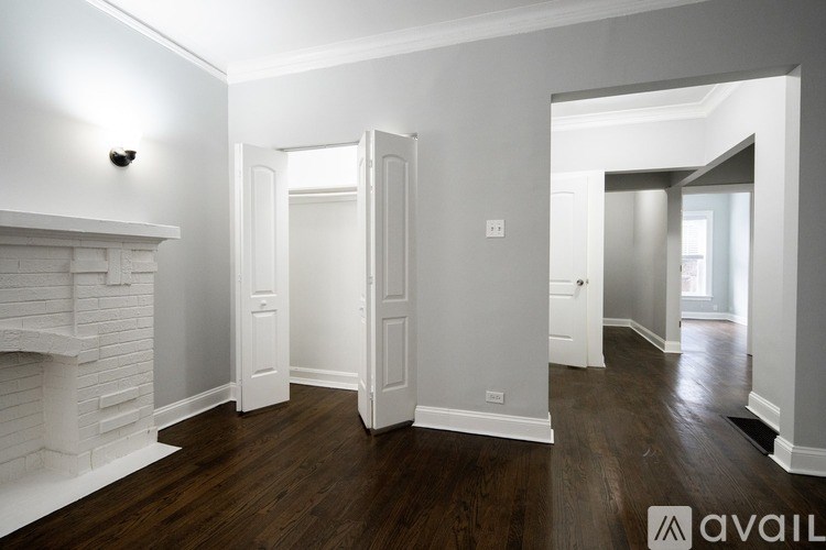 A room with a fireplace and wood flooring.