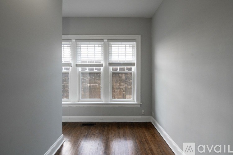 A room with a window and wooden floors.