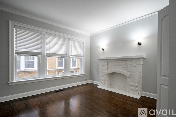 A room with a fireplace and a window with blinds.