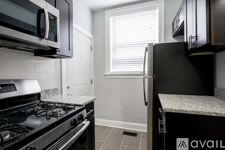 A kitchen with black appliances and white walls.
