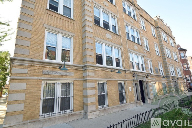 A building with a balcony and a black fence in front.