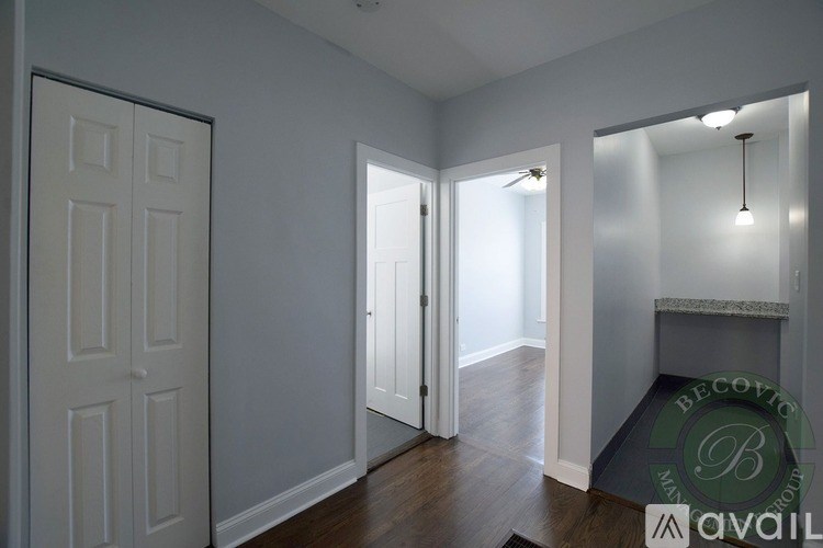 A room with a door on the left and a fireplace on the right.