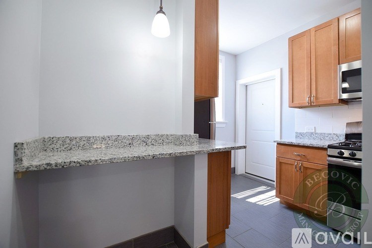 A kitchen with a granite countertop and wooden cabinets.