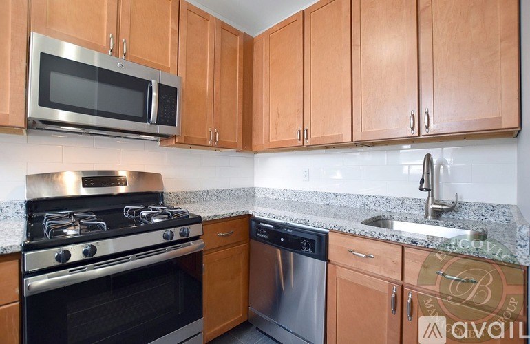A kitchen with wooden cabinets and a stainless steel oven.