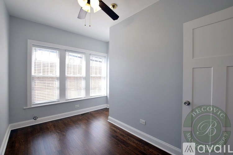 A room with a wooden floor and a ceiling fan.