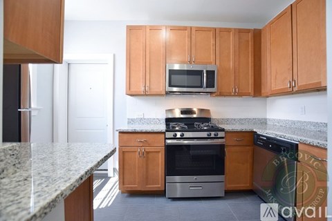 A kitchen with wooden cabinets and granite countertops.